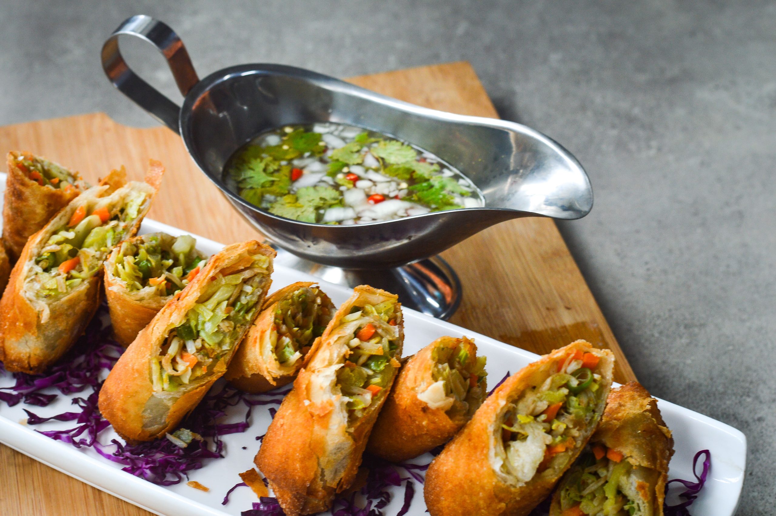 plated egg rolls with a vinegar dip on the side